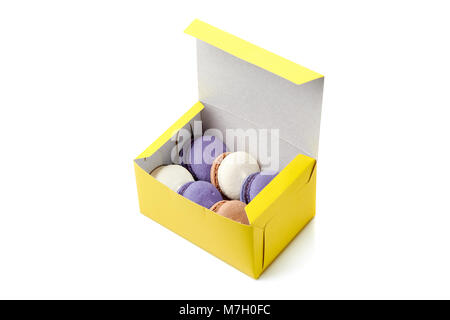 Yellow packing box with colorful macaroons on white Stock Photo