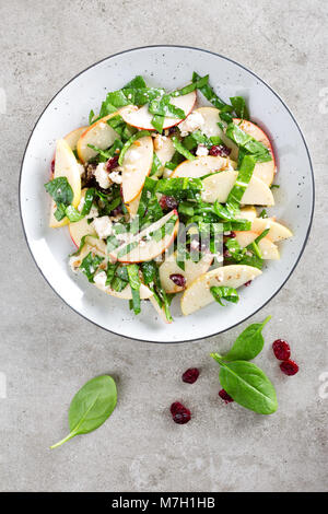 Healthy fruit and berry salad with fresh apples, cranberries, walnuts, italian ricotta cheese and spinach leaves. Delicious and nutritious diet dish f Stock Photo