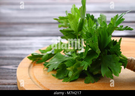 Fresh green parsley on the wooden table, selective focus Stock Photo