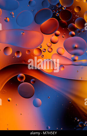 Mixing water and oil, beautiful color abstract background based on red and yellow circles and ovals, macro abstraction. Abstract colorful background.  Stock Photo