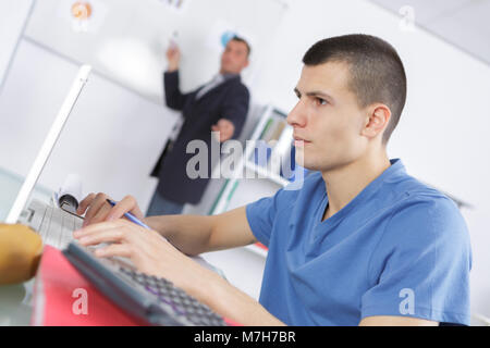 student working out problems on his calculator Stock Photo