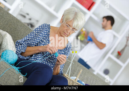 old woman knitting by the window Stock Photo