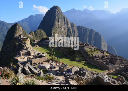 Sunrise over tourists at Machu Picchu in the Andes Mountains of Peru.