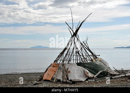 Remains of a camp on the beach of Ola on the Okhotsk sea. In the distance is the Zavyalov Island on the left and Cape Taran on the right. Stock Photo