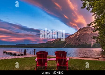 Red chairs in the sunset light at Waterton Lakes National Park, Canada. Stock Photo