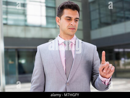 Businessman pressing imaginary button on large plant background Stock Photo