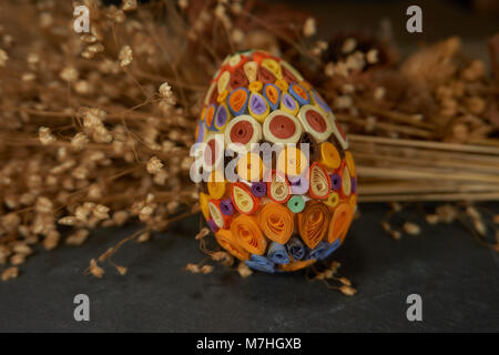Easter egg decorated with the quilling technique and dried flower bouquet. Easter decor, selective focus. Stock Photo