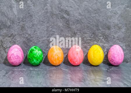 Colorful Easter eggs in front of grey background Stock Photo