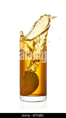 apple slice falling into juice creating splashes. Isolated on white background. Glass of splashing juice Stock Photo
