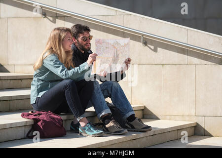 Tourists sitting on steps reading their map, Bilbao, Pais Vasco, Spain, Stock Photo