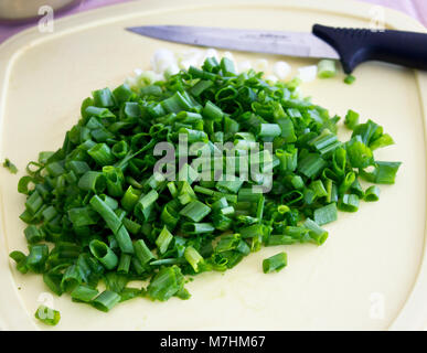 Sliced green onion on a cutting board with the knife Stock Photo