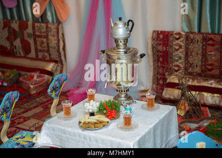 Novruz holiday background . Semeni on vintage plate decorated . Samovar and teapot . Samovar on a background of Novruz holiday . Tea in the tablecloth cups Stock Photo