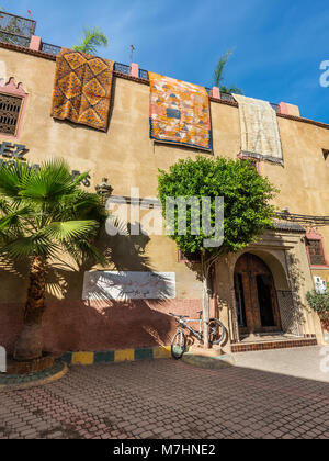 Marrakesh, Morocco - December 8, 2016: Beautiful street and carpets on houses of old medina in Marrakesh, Morocco, Africa. Stock Photo