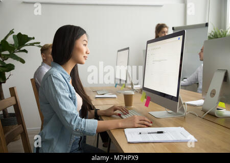 Young asian businesswoman using computer working online in cowor Stock Photo