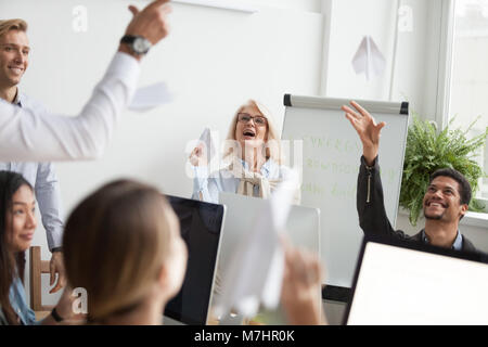 Successful team of happy diverse employees launching paper plane Stock Photo