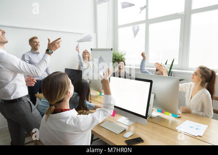 Multiracial motivated employees launching paper planes together, Stock Photo