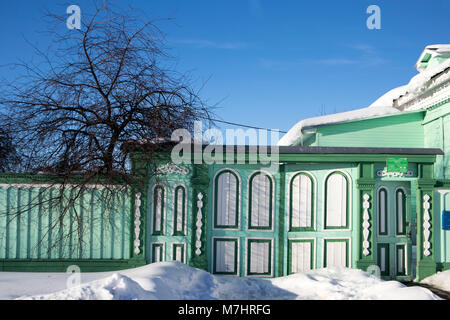 KOLOMNA, RUSSIA - 10 March 2018 Wooden painted carved gates in Arts nouveau covered with snow. Facade of a wooden house. Decorative wood carving. Russ Stock Photo