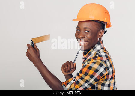 African-American builder uses measuring tape Stock Photo