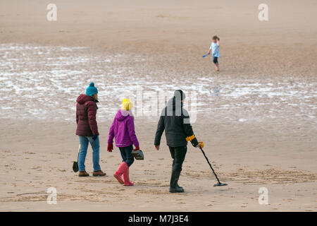 Blackpool, Lancashire. UK Weather. 11th March, Metal dectorists scour the beach for archaeology looking for treasure, equipment, discovery, history, sensor, adventure, electrical, searching, detect, finding lost items. holding detecition instrument. Credit: MediaWorldImages/Alamy Live News Stock Photo
