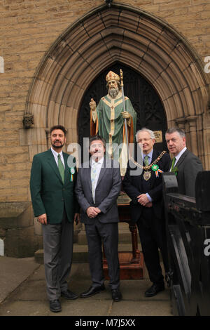 Manchester, UK 11 March 2018. Manchester Irish Festival March 2018.  The parade commenced at the Irish World Heritage Centre, In Cheetham Hill, Manchester and finished outside the town hall. John Flanagan (righy) is pictured outside a statue of St. Patrick @ St. Chads Church Credit: Gerard Noonan/Alamy Live News Stock Photo