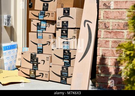 Amazon Prime boxes delivered and stacked at the front door of a residential home, USA Stock Photo