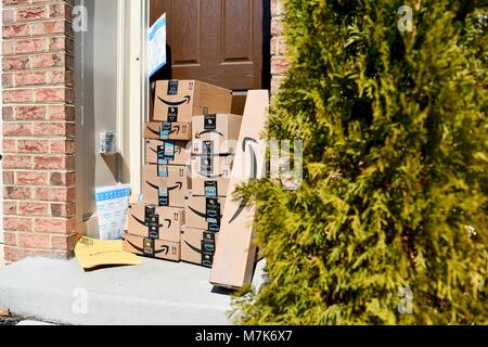 Amazon Prime boxes delivered and stacked at the front door of a residential home, USA Stock Photo