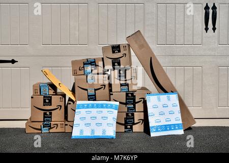 Shipment of Amazon Prime boxes and packages delivered and left in front of garage at a residential home, USA Stock Photo