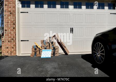 Shipment of Amazon Prime boxes and packages delivered and left in front of garage at a residential home, USA Stock Photo