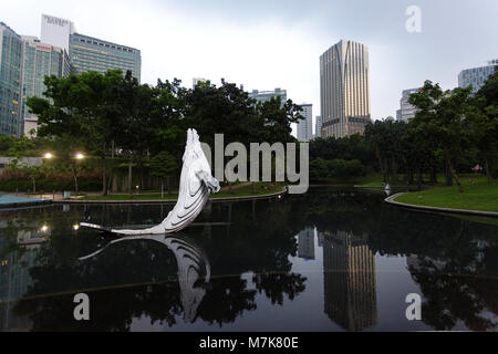 Pond with sculptures of whale and doplphins in the KLCC park. Kuala Lumpur, Malaysia