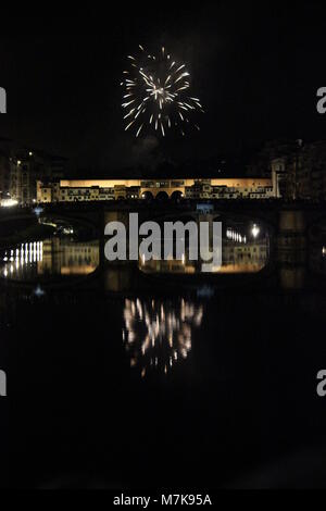 FLORENCE, ITALY - JUNE 24 2013: Fireworks by the historic Ponte Vecchio bridge in Florence, for the patron saint day Stock Photo