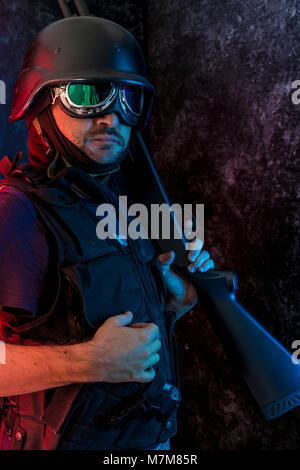 Thief, man armed with shotgun and bulletproof vest Stock Photo