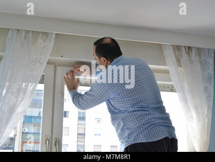 Man doing a housework, marking position for installing a new blind Stock Photo