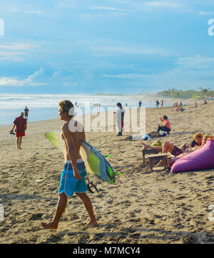 CANGGU, BALI ISLAND, INDONESIA - JAN 19, 2017: Surfers walking with surfboard on the beach. Bali island is one of the worlds best surfing destinations Stock Photo