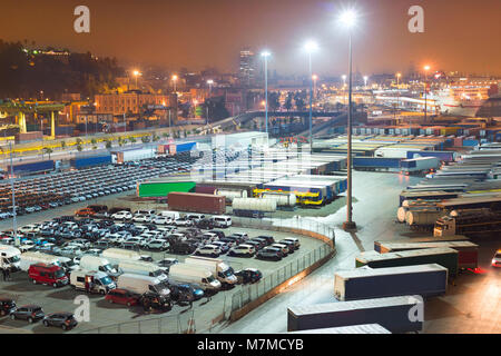 Cars and trucks on a large parking space at Barcelona industrial port at night. Spain Stock Photo