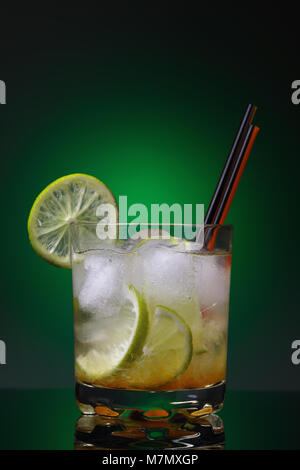 Traditional Brazilian cocktail of kaipirinha on a green background. Freshly prepared alcoholic beverage Stock Photo