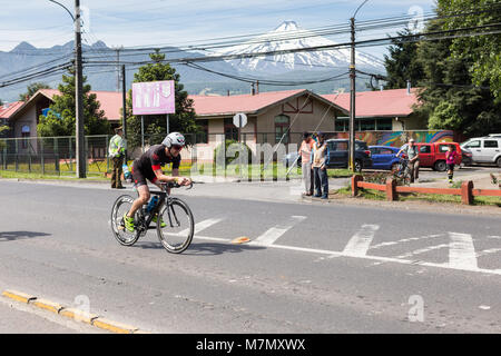 Athletes on their bikes passing through a town during Ironman 70.3 Pucon 2018 Stock Photo