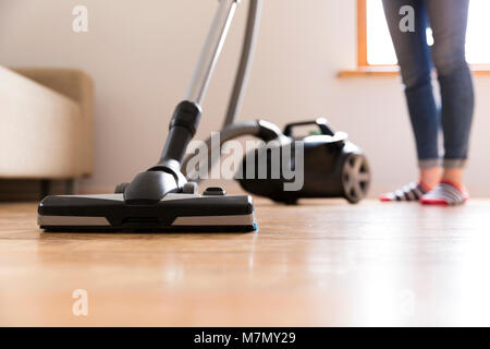 People, housework and housekeeping concept - happy woman with vacuum cleaner at home. Spring cleaning Stock Photo