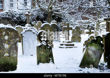 snow scene Grave yard, graves and headstones in the white snow, Ringmer church, East Sussex, UK Stock Photo