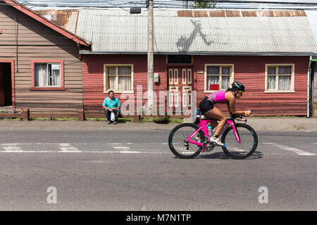 Athletes on their bikes passing through a town during Ironman 70.3 Pucon 2018 Stock Photo