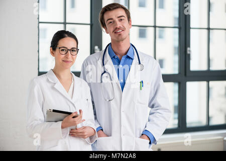 Two dedicated doctors smiling at camera Stock Photo