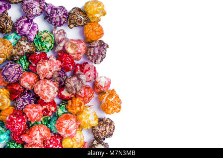 Brightly Colored Candied Popcorn, white background. Horizontal image of Junk food, fruit flavored popcorn. Colorful, rainbow, candy coated popcorn. Sh Stock Photo