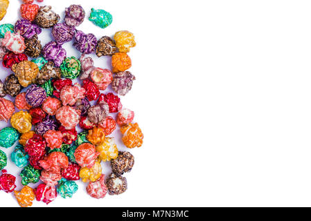 Brightly Colored Candied Popcorn, white background. Horizontal image of Junk food, fruit flavored popcorn. Colorful, rainbow, candy coated popcorn. Sh Stock Photo