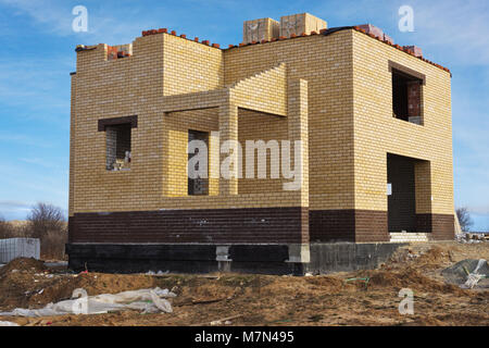 Individual house of yellow brick under construction Stock Photo