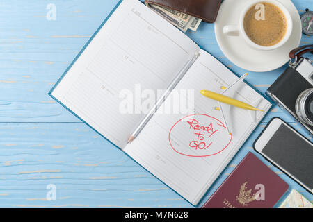 Pencil on note book with vintage camera and smartphone on old wood background,  prepare to travel and Holiday concept and copy space Stock Photo