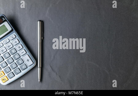 Office black stone desk table with calculator and pen, business background concept and copy space Stock Photo