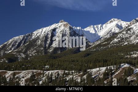 Scenic early Spring Panoramic Landscape View of Snowy Mountain Peaks above Canmore Alberta in Foothills of Canadian Rockies near Banff National Park Stock Photo