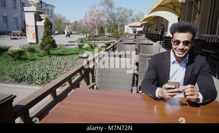 Arabian guy talking with friendby phone.  Stock Photo