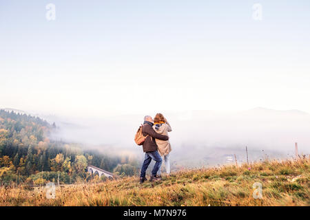 Senior couple on a walk in an autumn nature. Stock Photo