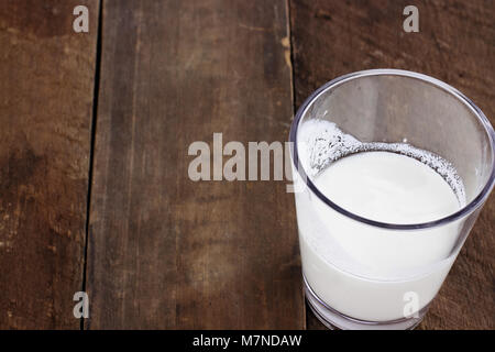 Kefir milk over rustic wooden background shot from overhead. Kefir is one of the top health foods available providing powerful probiotics. Stock Photo