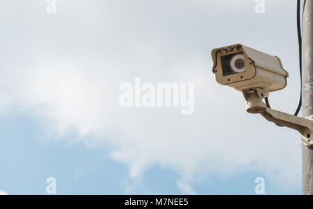 closed-circuit camera on white clouds background, closed-circuit camera on electric pole, Stock Photo
